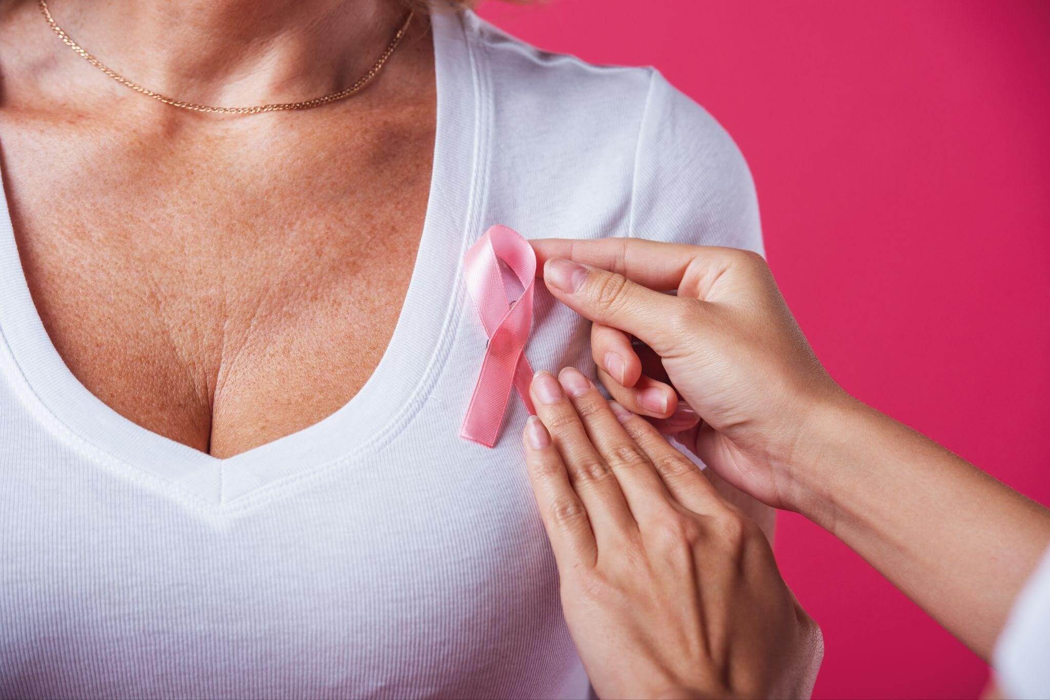 Imagem de mulher com laço rosa, símbolo do Outubro Rosa que promove campanhas contra o câncer de mama e incentiva o autoexame das mamas